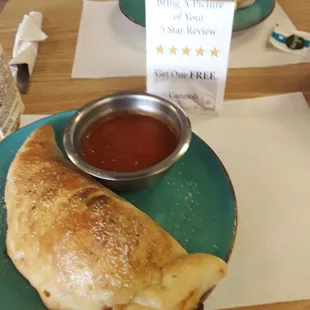 a plate of pizza and a bowl of tomato sauce