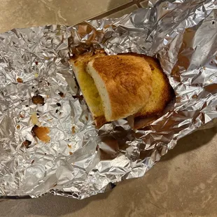 a half eaten sandwich wrapped in tin foil
