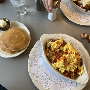 a breakfast of eggs, hash browns and pancakes