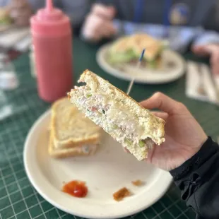 a person holding a sandwich on a plate