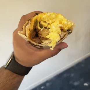 a hand holding a burrito