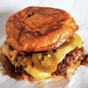 a hamburger with cheese and jalapenos