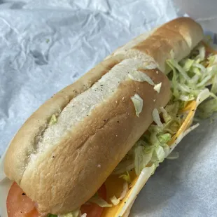 Full size three cheese sub with lettuce, tomato, mustard, Mayo, salt, pepper, oil and vinegar.