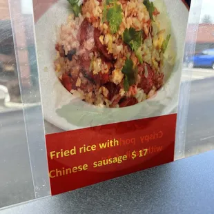 Fried rice with Chinese sausage advertisement inside restaurant.