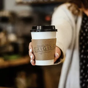 a woman holding a cup of coffee