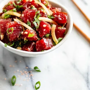 a bowl of food with chopsticks