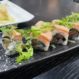 a variety of sushi on a black plate