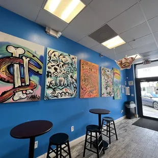 a blue wall with paintings on it