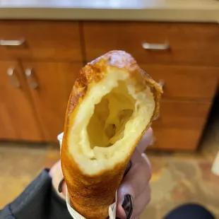 a person holding a pastry in their hand