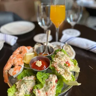a seafood platter with shrimp, lettuce, and tomato sauce