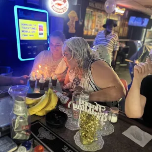 a woman blowing out candles on a cake