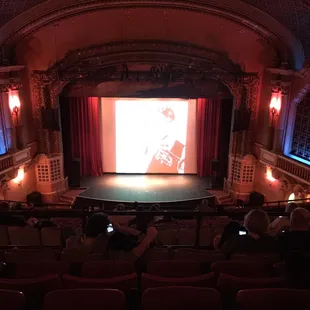 a man on stage with a projection
