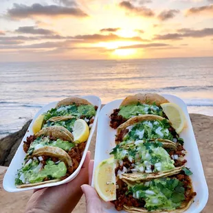 two plates of tacos on the beach