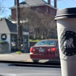 a cup of coffee on the dashboard of a car