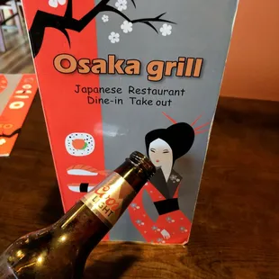 a bottle of beer in front of a sign