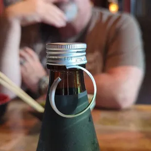 a man sitting at a table with a bottle of beer