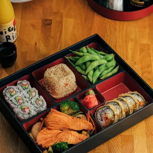 a bento box with sushi and vegetables
