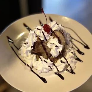 a banana split with whipped cream and a cherry on top