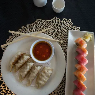 a plate of dumplings and a bowl of dipping sauce