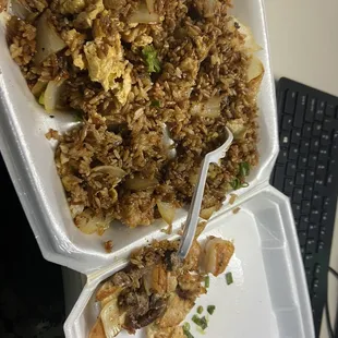 a take out container of food with a fork in it