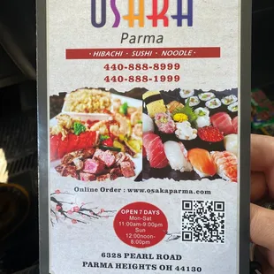 a hand holding up a menu