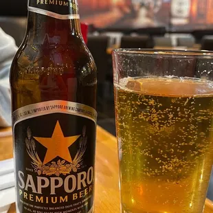a bottle of sappor beer next to a glass of beer