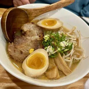 a bowl of ramen and a wooden spoon