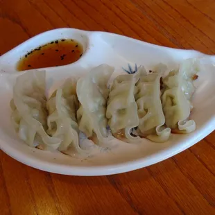 Pork gyoza with dipping sauce.