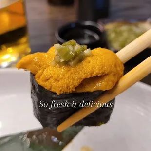 a sushi with chopsticks