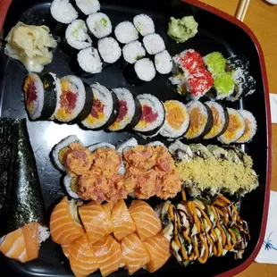 a variety of sushi on a black plate