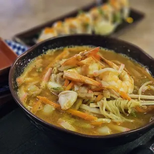 a bowl of soup with chopsticks