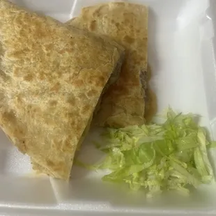 a tortilla and lettuce in a styrofoam container