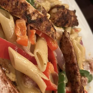 a plate of pasta with chicken and vegetables