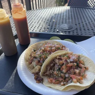 Carnitas and chicken tacos.  Two are plenty for me.  They come on corn tortillas