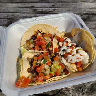 Three tacos, each with their own toppings.