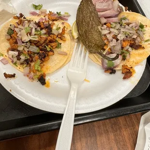 two tacos on a paper plate