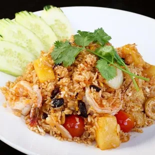 Pineapple Fried Rice -  Chicken, prawns, pineapple, egg, green peas, carrots, tomatoes, cashew nuts, raisins, and onions.