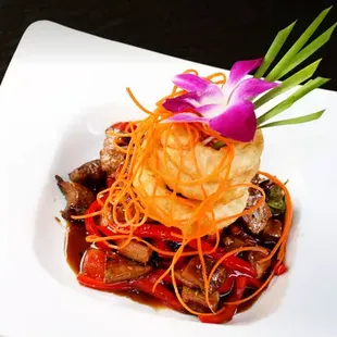 Volcanic Beef: Grilled angus flank steak, basil, black pepper, bell peppers in lava sauce with crispy onion rings