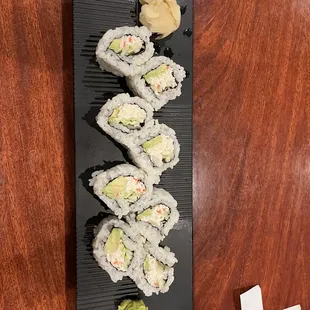 a plate of sushi on a wooden table