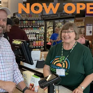 a man and a woman standing at a cash register