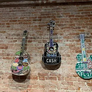 guitars hanging on a brick wall
