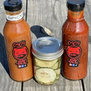 Bottle of house bbq sauce, apple habanero sauce, and jar of house pickles