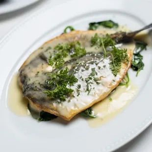a white plate with a fish dish on it