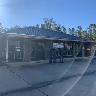 a group of people standing outside of a restaurant