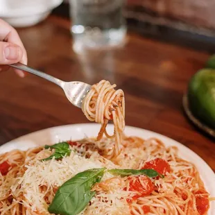 a plate of spaghetti with tomato sauce and basil