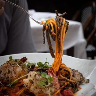 a plate of pasta with meat and vegetables