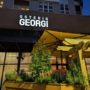 Osteria Georgi signage, outside at night. View facing south, southeast, from Village Plaza side.