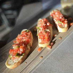 four pieces of bread with tomatoes on them