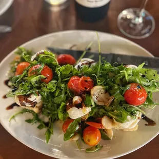 Tomatoes Vesta: Fire-roasted cherry tomatoes, lemon ricotta, arugula, red wine balsamic reduction, house-made focaccia