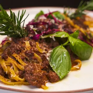 Tagliatelle Bolognese made with beef, cured prosciutto, sofritto, herbs and parmigiano